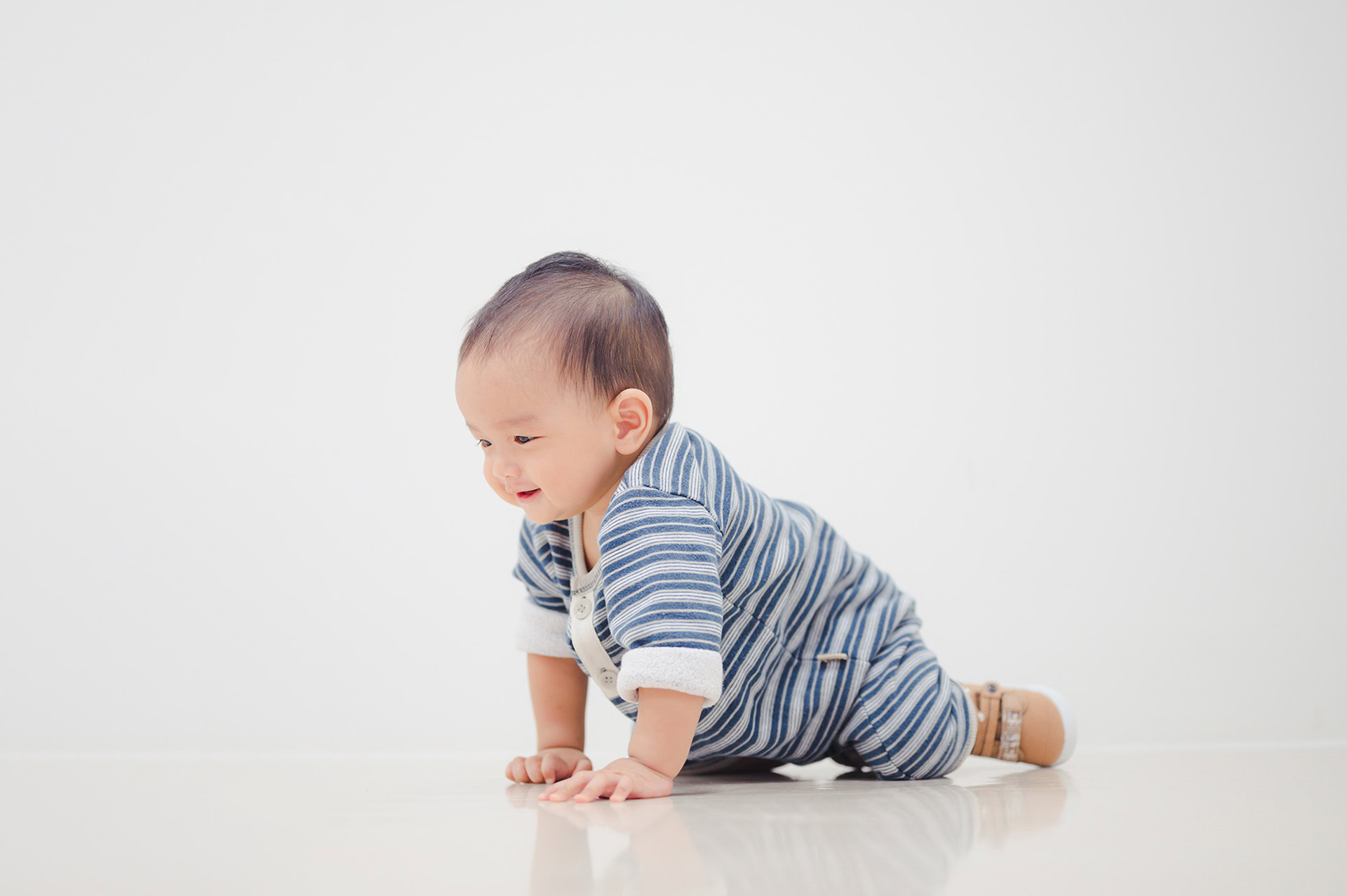 smiling crawling asian baby boy home floor