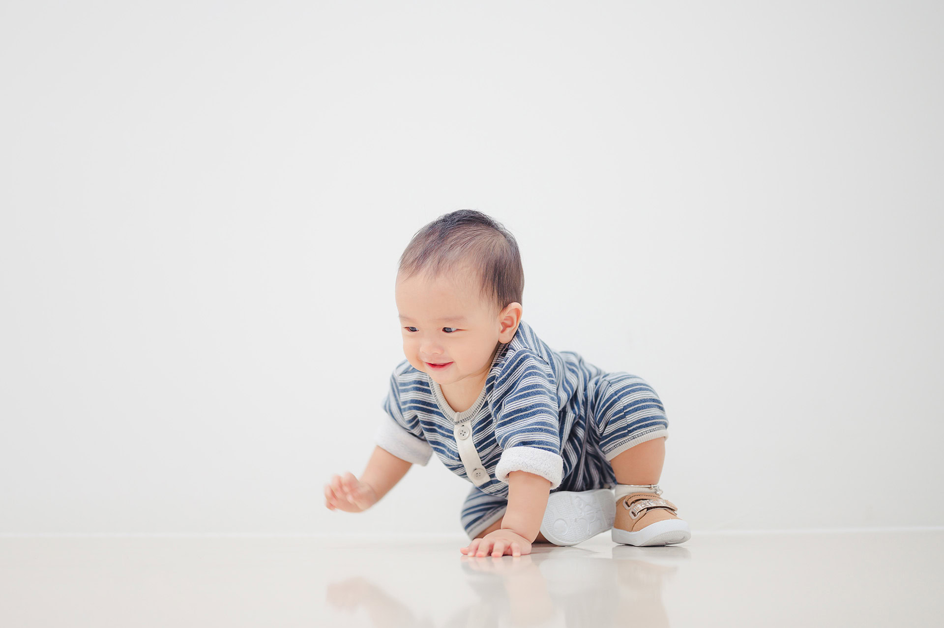 smiling crawling asian baby boy home